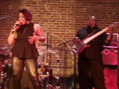 A somewhat blurry image of Keeshea Pratt on stage, singing.