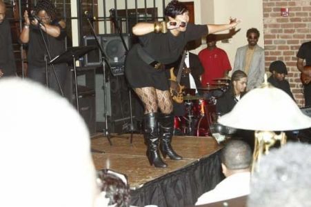A picture of Keeshea Pratt leaning out over the crowd while singing for the On Stage Gallery